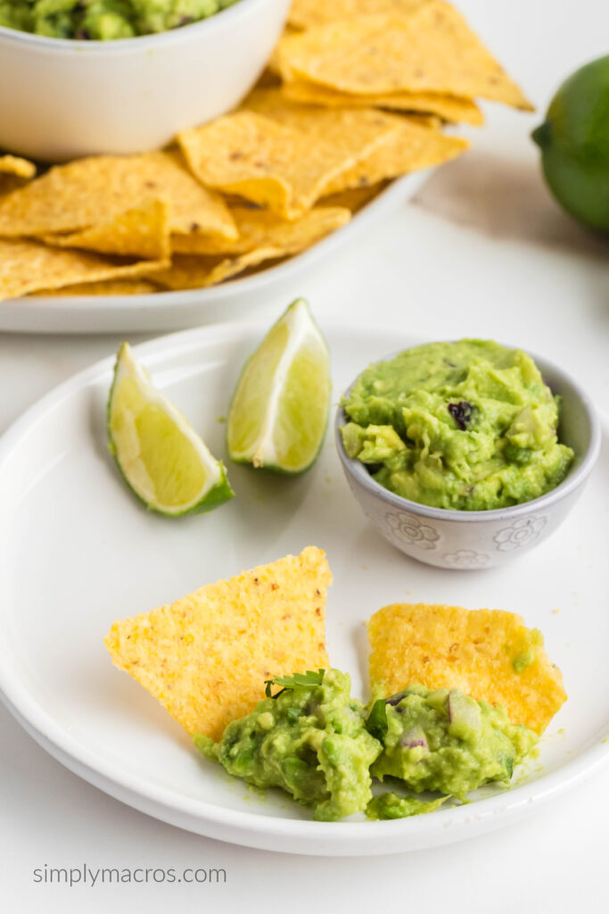 Guacamole on chips, with a small side of guacamole in a bowl, ready to eat. 