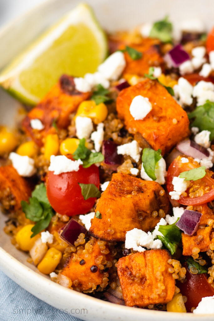 Quinoa sweet potato bowls topped with feta cheese and a wedge of a lime for serving. 