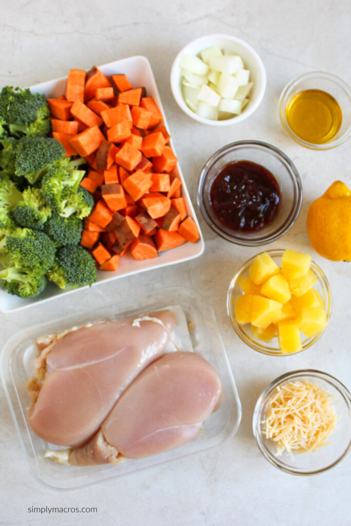 chicken, broccoli, sweet potatoes, BBQ sauce, onion, olive oil, lemon, pineapple, and cheese - ingredients to make sheet pan bbq chicken.