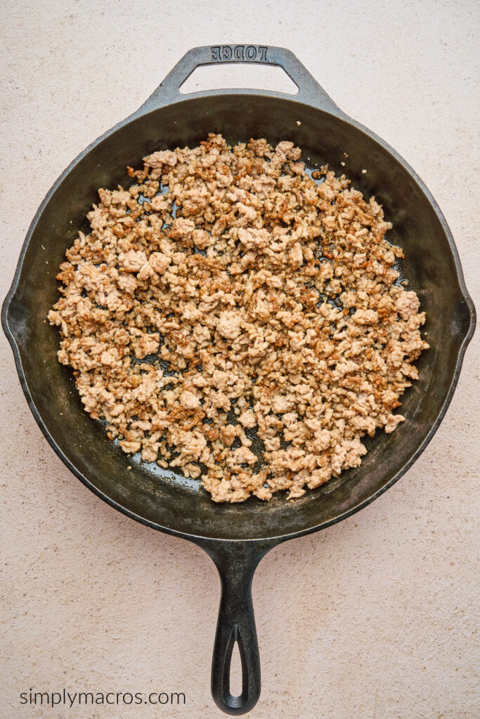 Ground beef in a skillet as a base for egg roll in a bowl. 