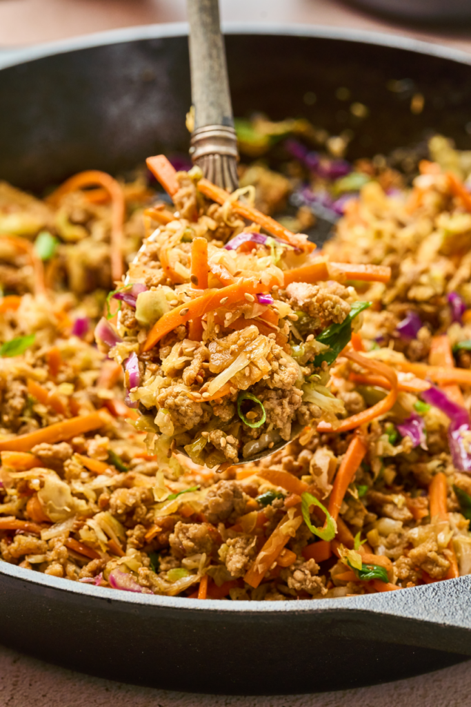 bite shot of the egg roll in a bowl recipe with a spoon directly from the skillet. 