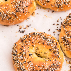 3 Ingredients cottage cheese bagels sprinkled with everything bagel seasoning, fully cooked on a baking sheet and ready to eat.