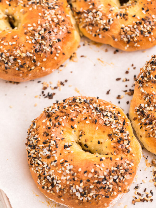 3 Ingredients cottage cheese bagels sprinkled with everything bagel seasoning, fully cooked on a baking sheet and ready to eat.