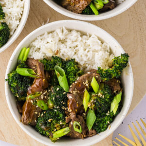 Air fryer beef and broccoli served over a bowl of rice.