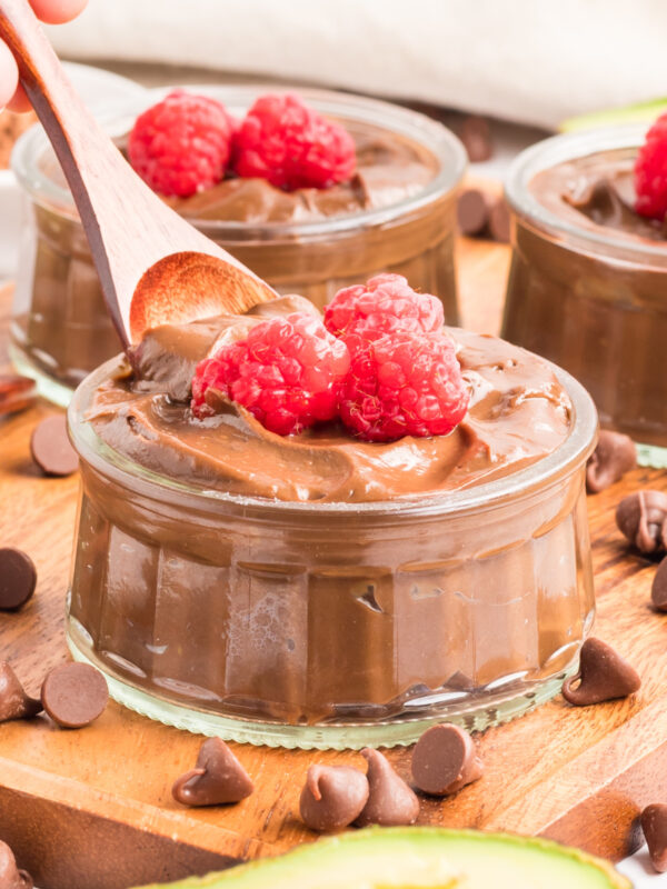 Avocado chocolate mousse in a bowl with fresh raspberries on top