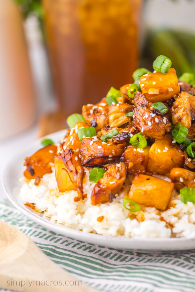 Brown sugar pineapple chicken served over a bed of rice and garnished with sesame seeds and diced scallions. 