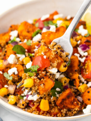 Quinoa sweet potato bowl with a fork, ready to eat.