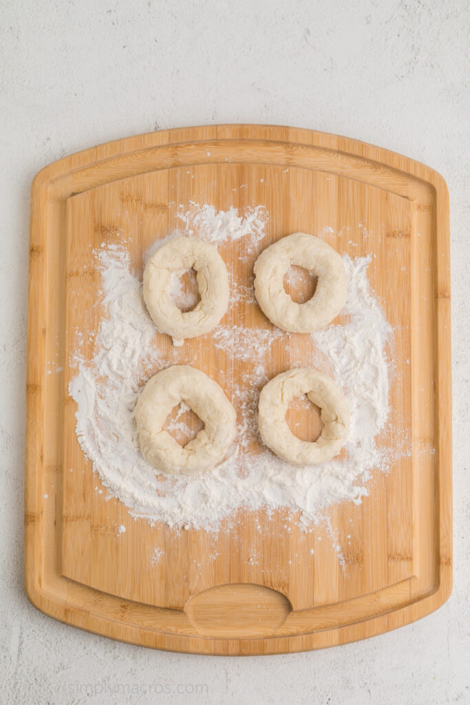 Dough divided and bagels created on a work surface. 