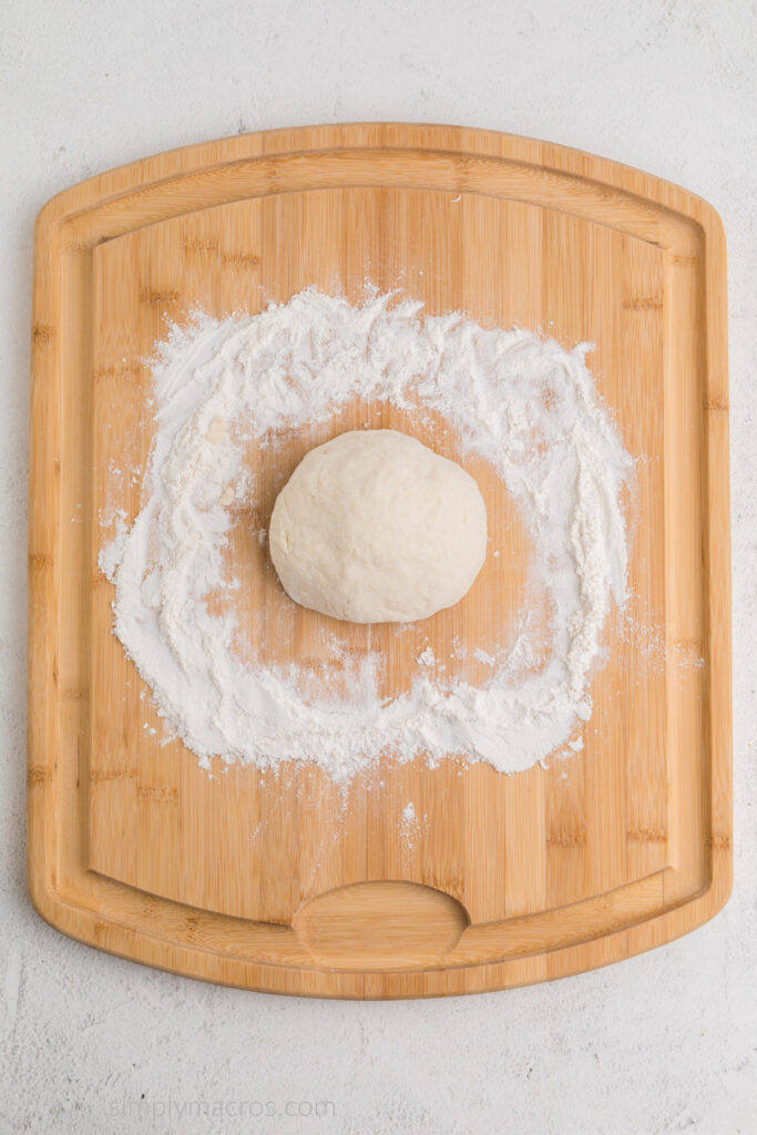 Dough on a wooden work surface that has been kneaded until smooth. 