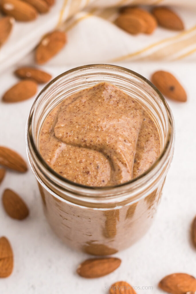 Close up of creamy, smooth, homemade almond butter in a jar. 