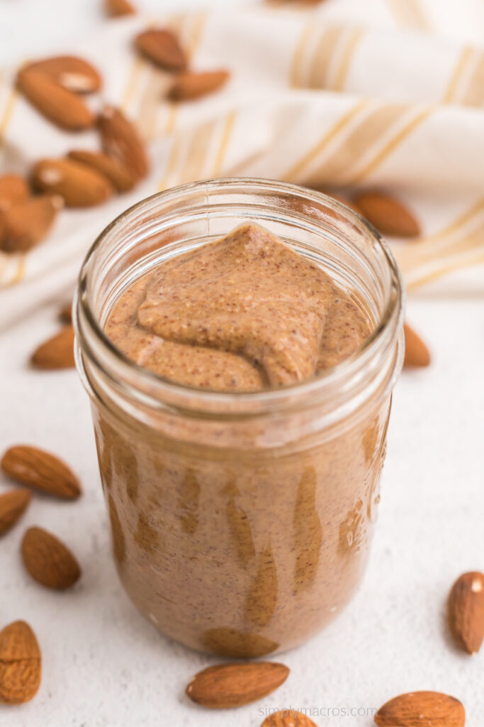 Creamy homemade almond butter in a glass storage jar. 