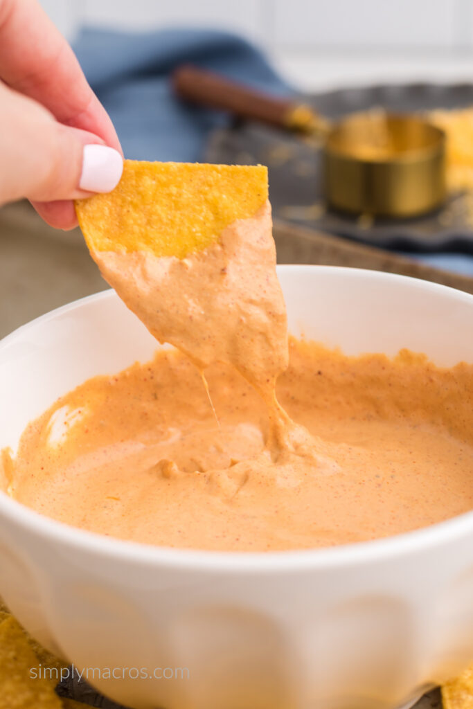 Tortilla chip being dipped into the cottage cheese queso. 