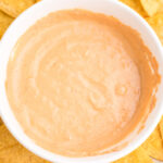 Overhead picture of cottage cheese queso in a bowl surrounded by chips. Pinnable image.