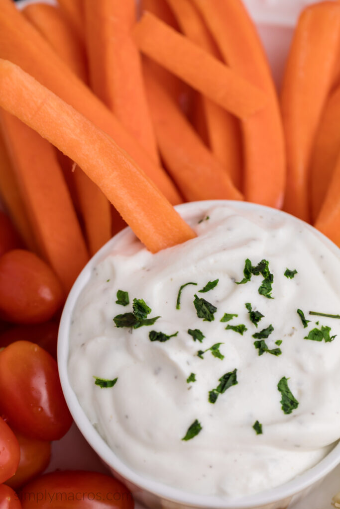 Close up of cottage cheese ranch dip in a bowl with a carrot stick. 