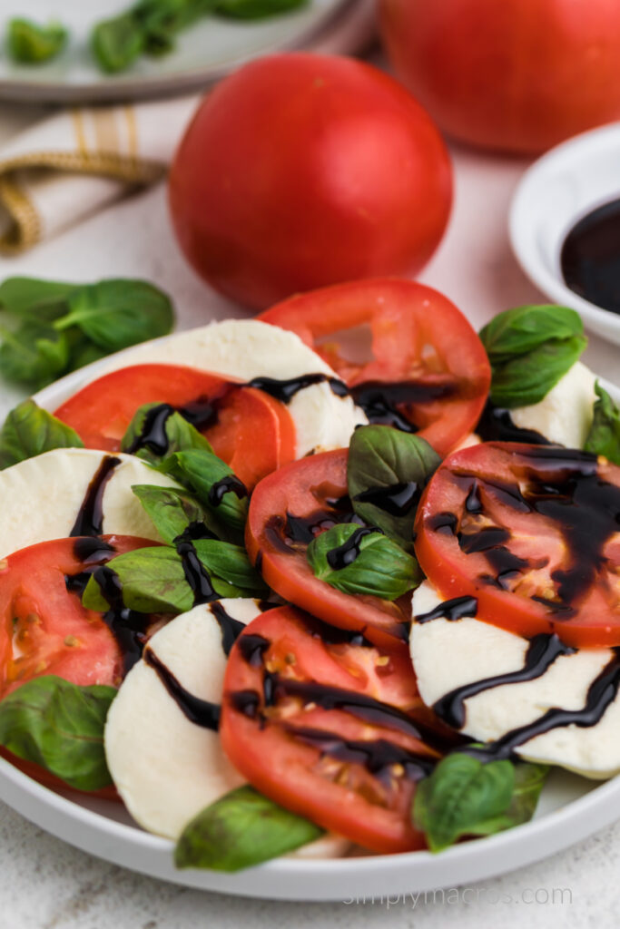 Close up of a caprese salad drizzled with balsamic glaze. 