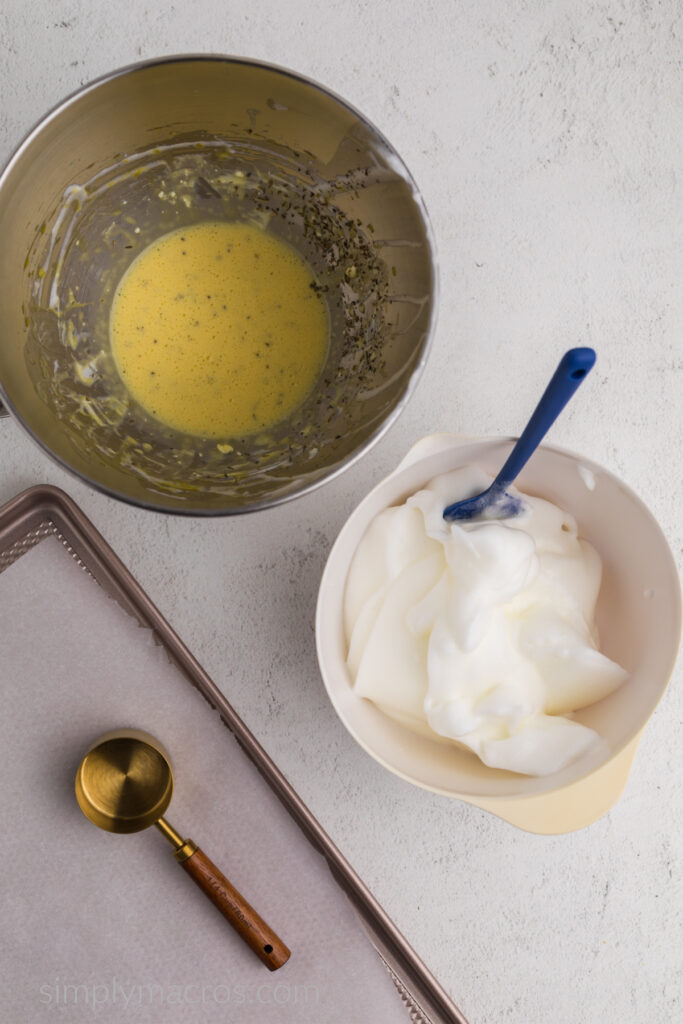 Stand mixer bowl with egg and cream cheese mixture and bowl with whipped egg whites, ready to combine and bake. 