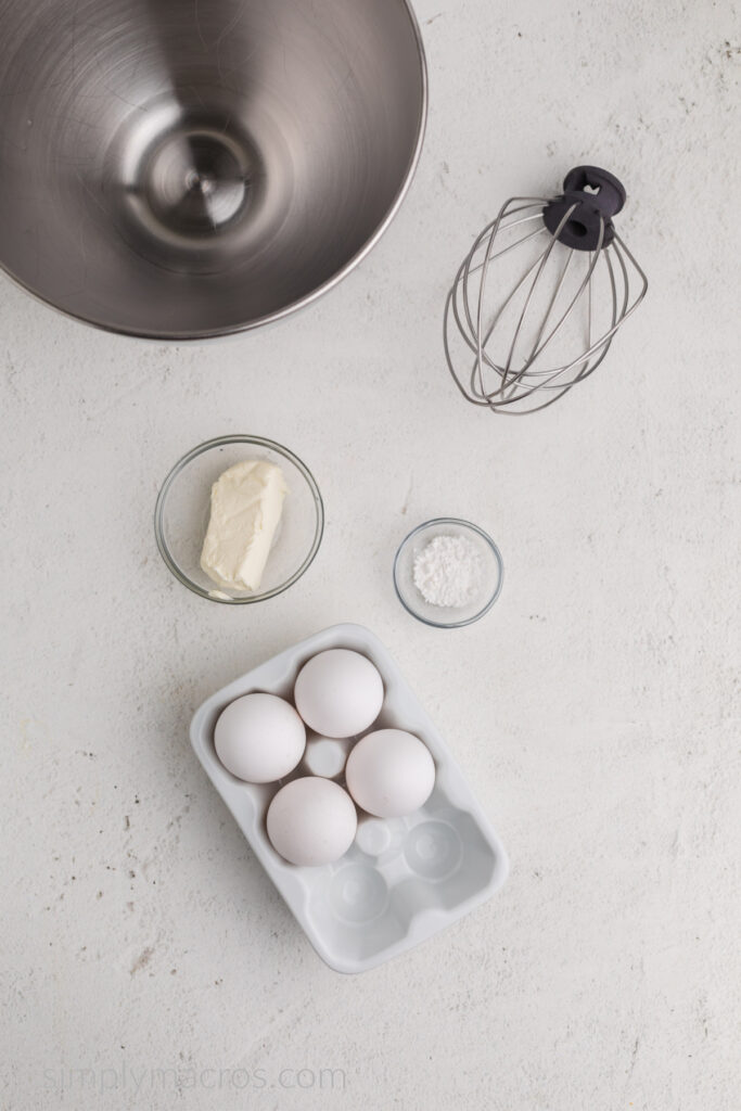 Eggs, cream cheese, and cream of tartar used to make cloud bread, with a bowl for a stand mixer and a whisk attachment. 