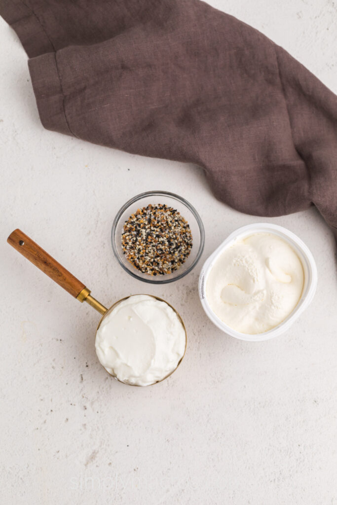 Ingredients needed to make everything bagel dip on a table top. 