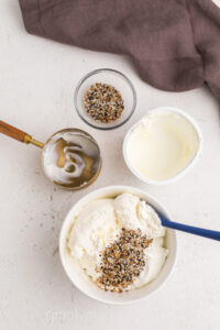 Ingredients for everything bagel dip combined in a bowl.