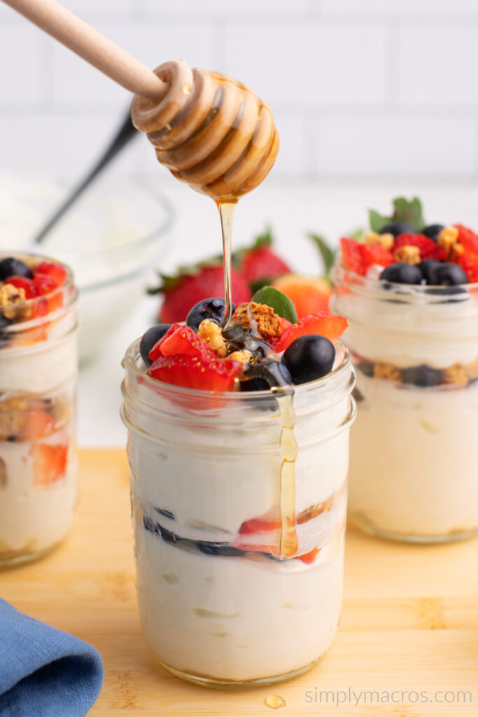 Greek Yogurt Parfait being drizzled with honey. Ready to eat. 