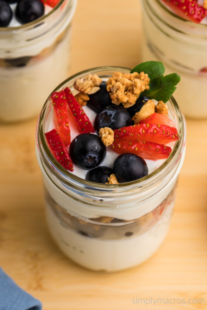 Close up overhead angled shot of a Greek Yogurt Parfait topped with berries and granola. 