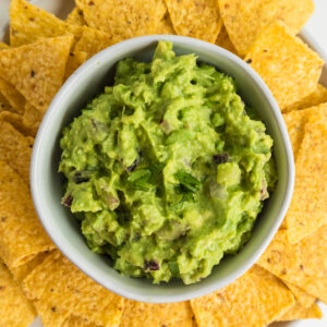 Overhead photo of guacamole surrounded by fresh corn chips.