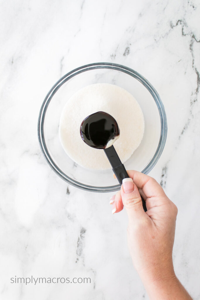 Molasses ready to be poured into a bowl of white sugar. 