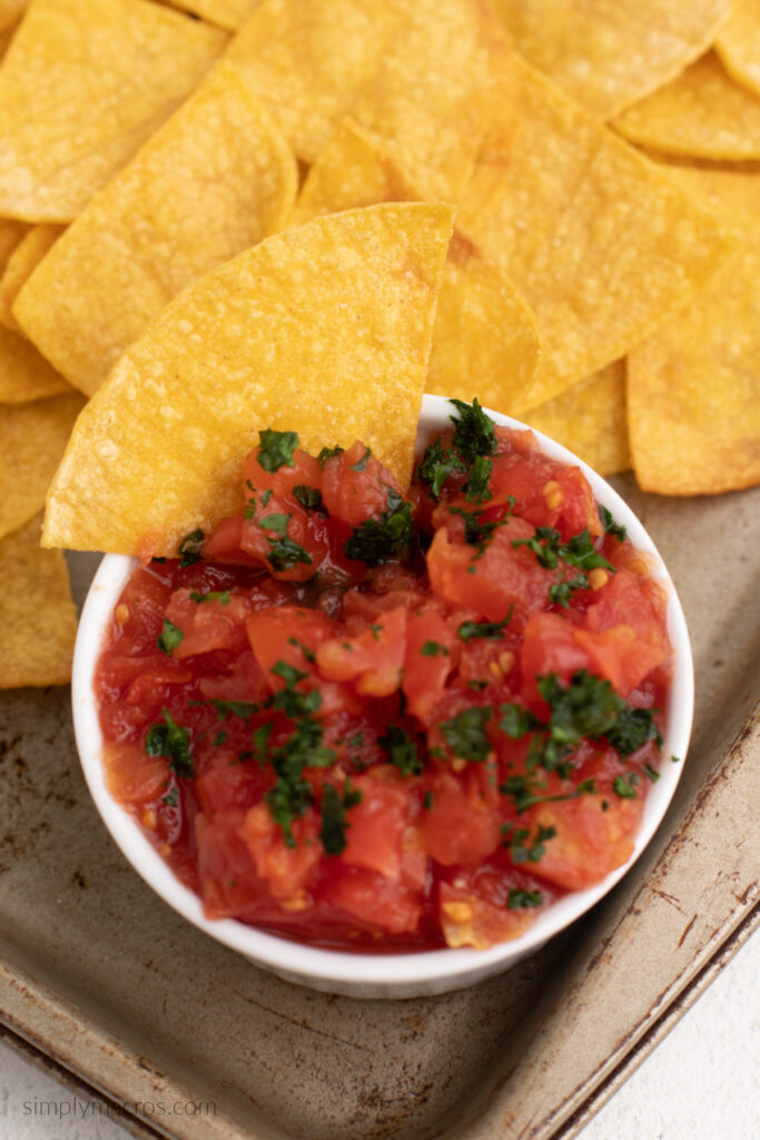 Homemade tortilla chip being dipped in salsa. 