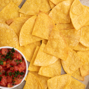 Homemade tortilla chips on a tray with a side of salsa.