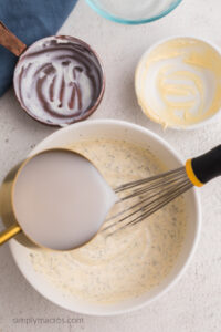 almond milk being whisked into the mixture to create the desired consistency for the low calorie ranch.