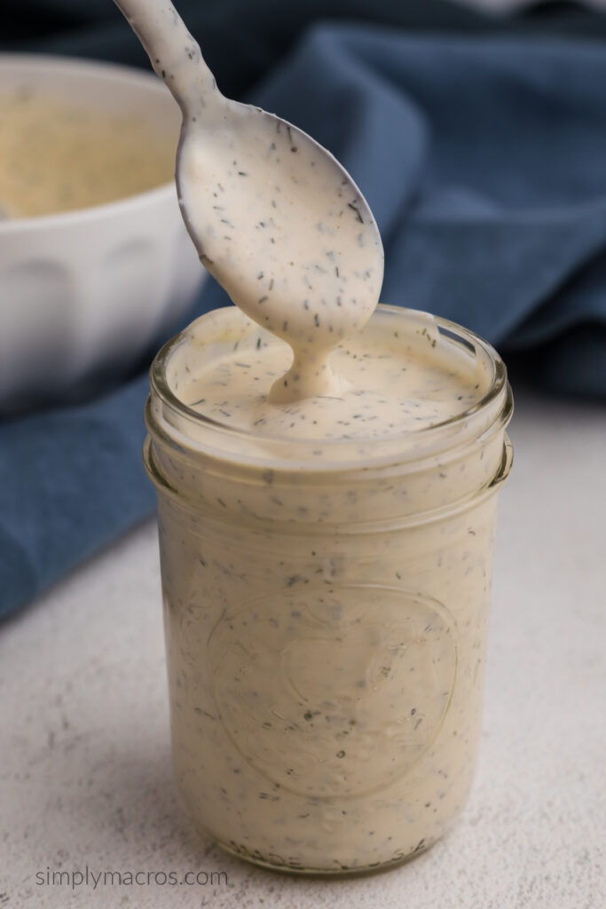 Close up of low calorie ranch dressing being scooped from a jar. 