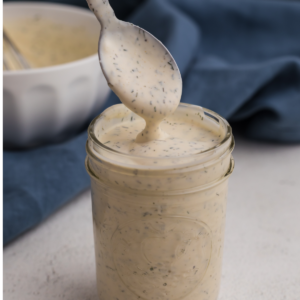 Low calorie ranch dressing in a jar being spooned out, ready to serve.