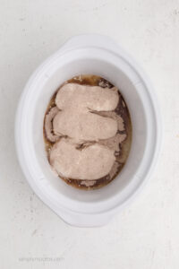 seasoned chicken in the bottom of the slow cooker.