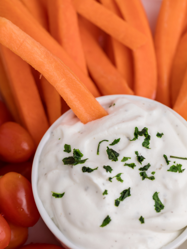 Cottage cheese ranch dip with a carrot being dipped into it.