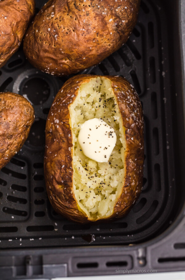 Cooked baked potato in air fryer basket.