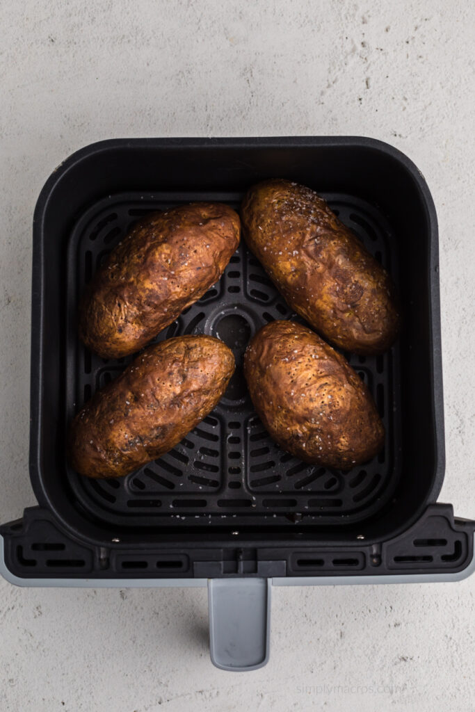 Russet potatoes fully cooked and in the air fryer basket, ready to slice and serve. 