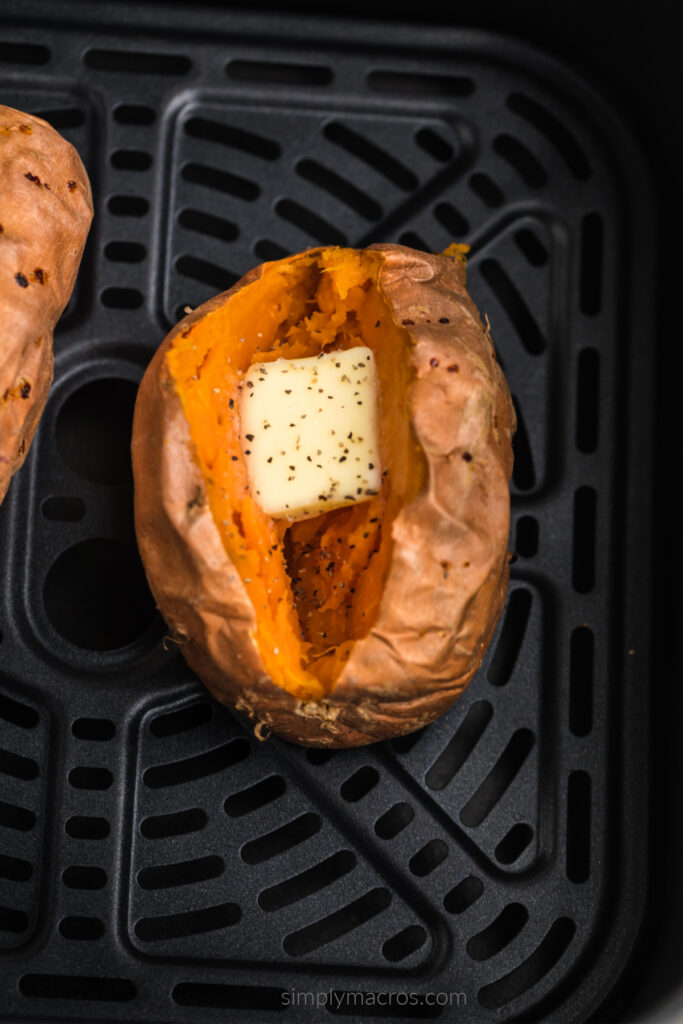 Overhead shot of a baked sweet potato in air fryer basket. 