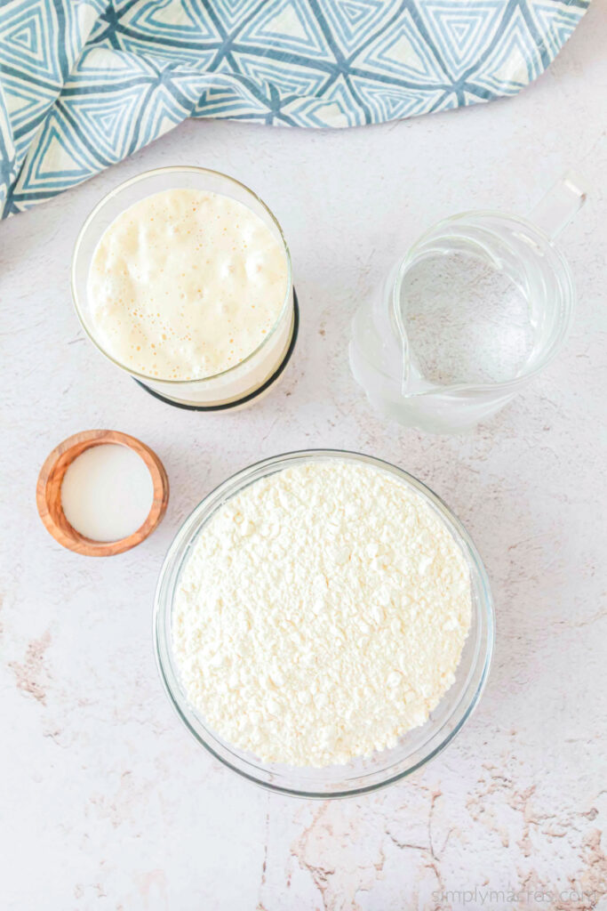 Ingredients needed to make sourdough bread on a table. 