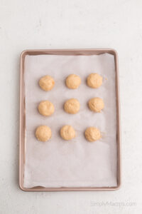 balls scooped onto a parchment lined sheet.