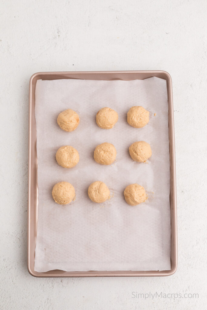 Peanut butter protein balls on a lined baking sheet. 