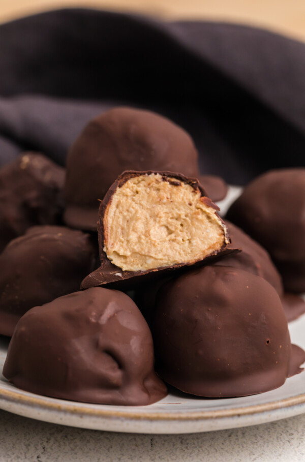 High protein peanut butter balls with one cut in half on top.