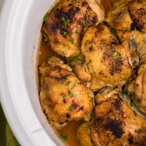 Chicken thighs in slow cooker, fully cooked and ready to serve.