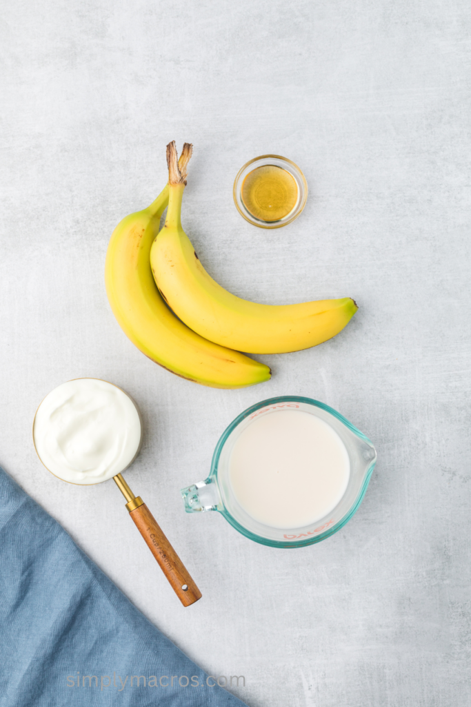 Ingredients on a table top needed to make a banana smoothie.