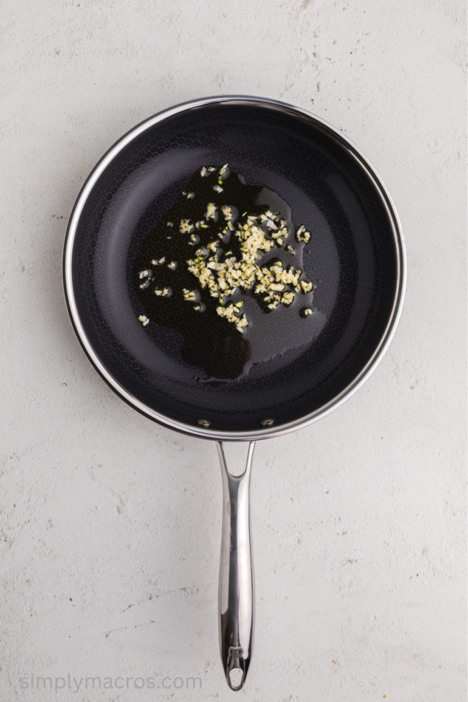 Garlic and olive oil being heated in a skillet. 