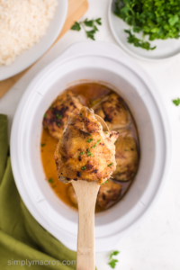 chicken thigh over the slow cooker in a spoon.