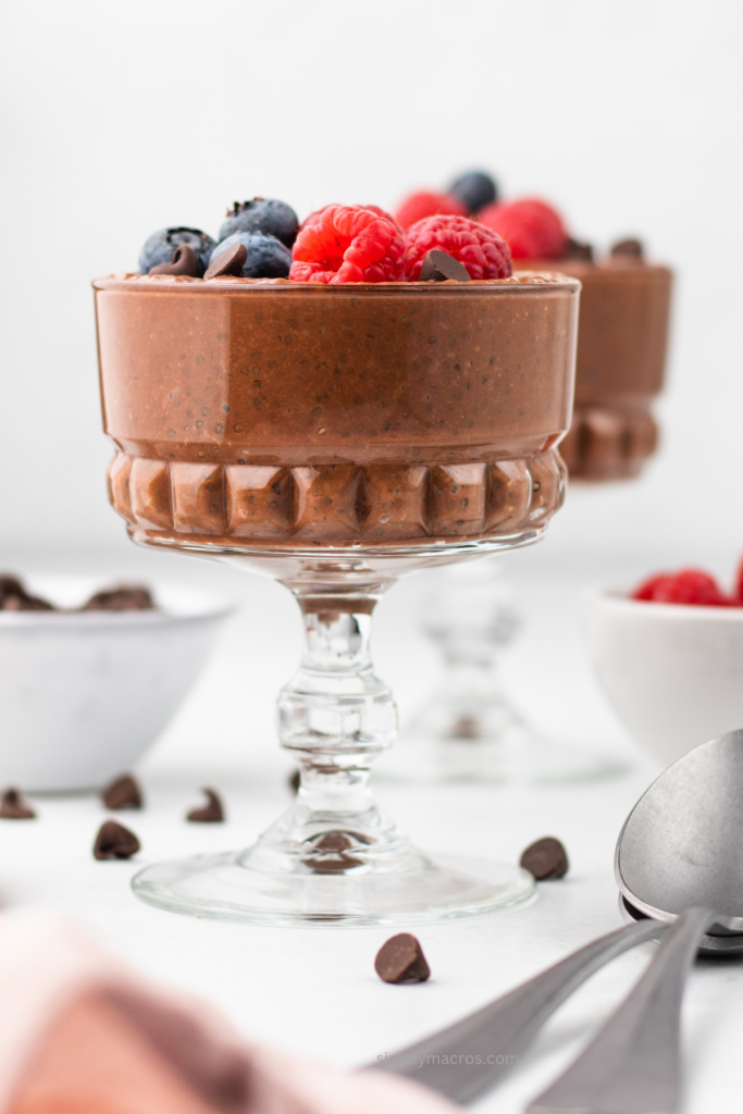 Chocolate chia pudding in a dish and topped with fresh berries and chocolate chips.