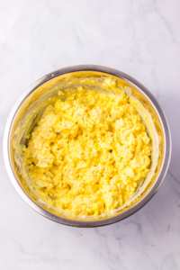 Ingredients for deviled egg dip mashed and in a mixing bowl.