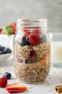 Overnight oats layers with mixed berries in a jar.