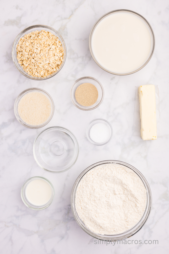 Ingredients for oat bread portioned out into separate bowls on a table top. 