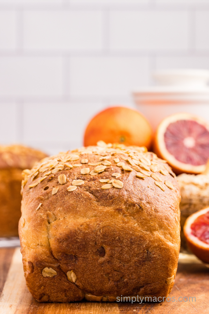 Oatmeal bread on a cutting board, ready to be sliced. 